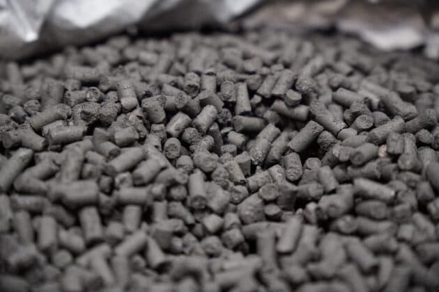 A close-up pile of dark gray biocarbon pellets.